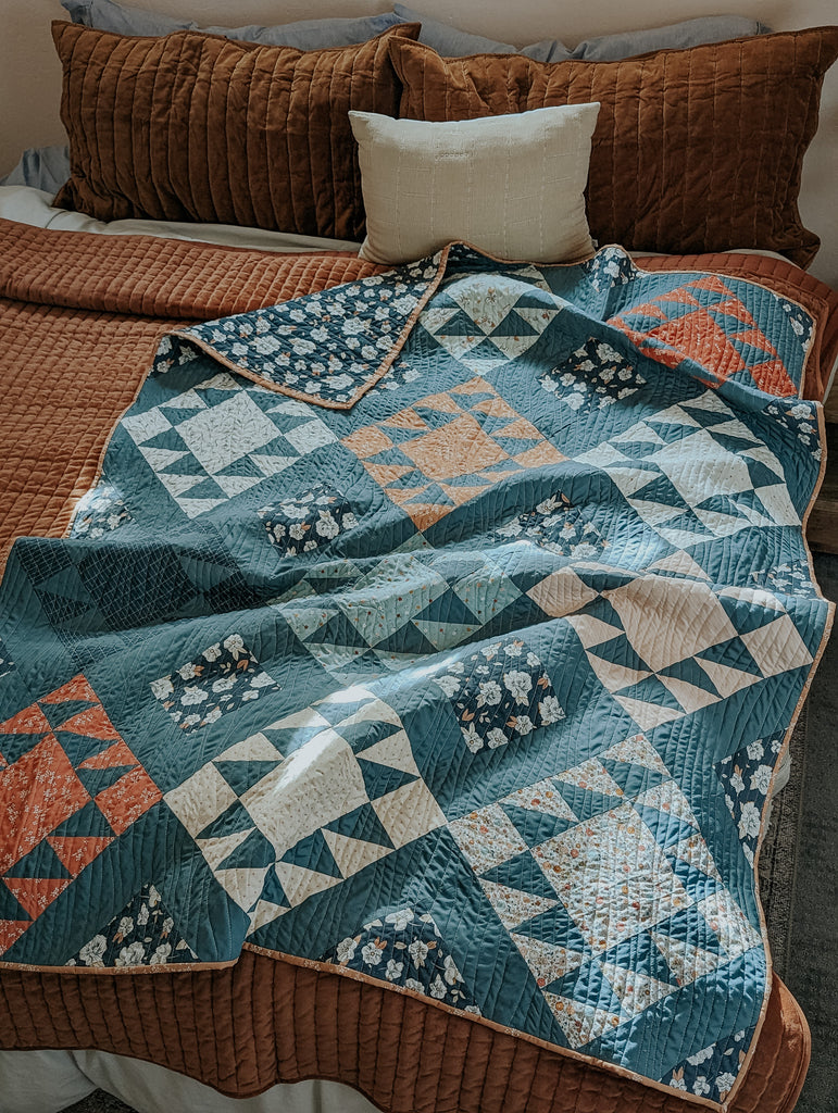 Throw size, scrappy version Mountain Dweller quilt created by Amy of Ritual Quilt Company. Feature fabrics are all Art Gallery Fabrics; Gayle Loraine collection by Elizabeth Chappell and AGF solid in Northern waters. 